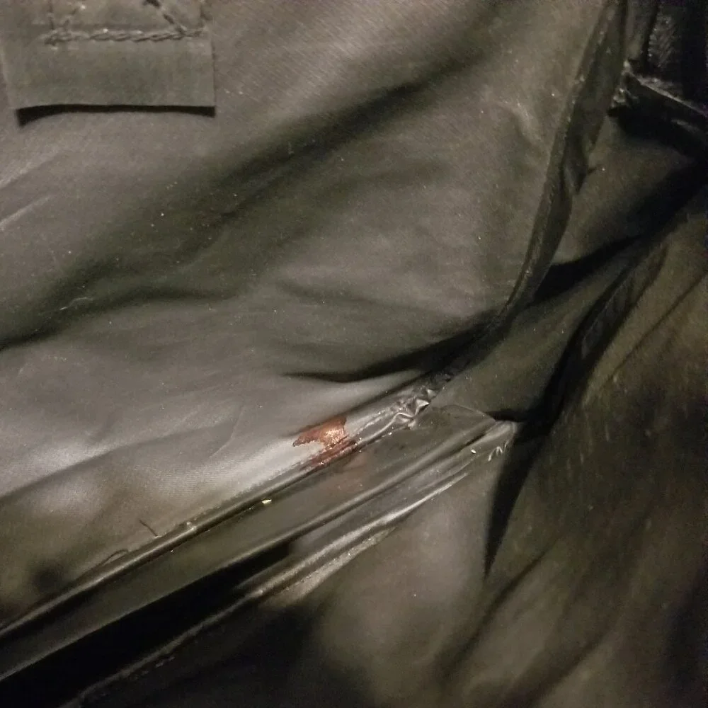 large black bag with straps, and ink-stained interior